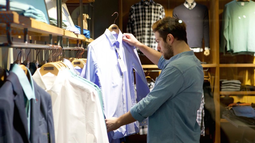 Young man shopping for clothes at store